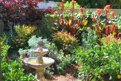 Inspiration for a mid-sized traditional full sun backyard water fountain landscape in Orange County.