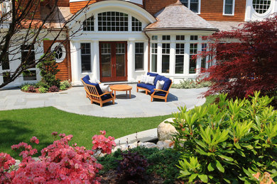 This is an example of a large traditional full sun backyard stone landscaping in Boston.