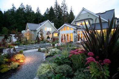This is an example of a large classic back formal partial sun garden in Seattle with a garden path and natural stone paving.