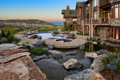 This is an example of a rustic full sun backyard pond in Denver.