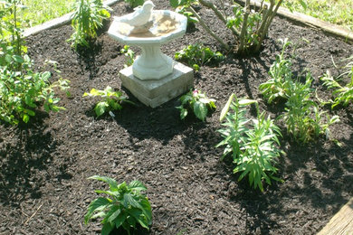 Foto de jardín tradicional de tamaño medio en patio delantero con jardín francés, exposición total al sol y mantillo