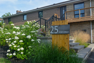 This is an example of a mid-sized contemporary partial sun front yard stone landscaping in Toronto for summer.