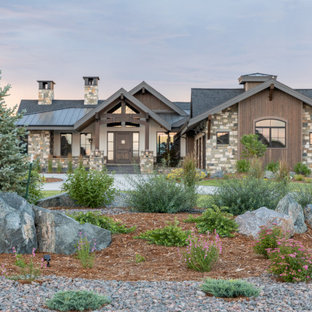 Immagine di un ampio vialetto d'ingresso stile americano esposto in pieno sole davanti casa con sassi e rocce e pacciame