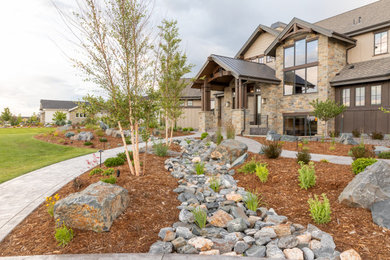 Photo of a huge craftsman rock and full sun front yard mulch landscaping in Denver.