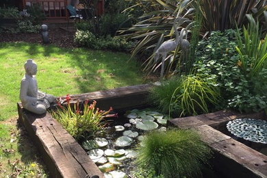 Inspiration for a mid-sized rustic partial sun backyard stone pond in Essex for summer.