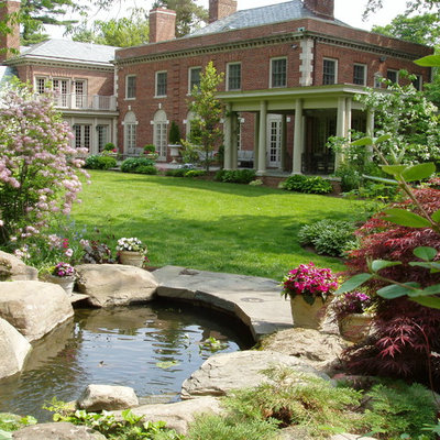 Photo of a mid-sized traditional partial sun backyard stone landscaping in Philadelphia.