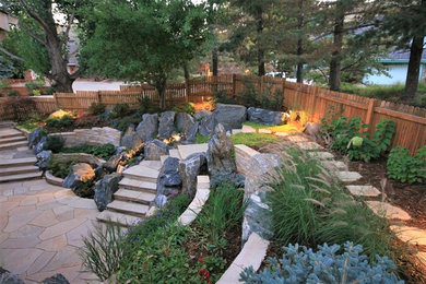 Photo of a medium sized classic back formal partial sun garden for summer in Denver with a retaining wall and natural stone paving.
