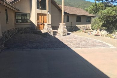 Photo of a mid-sized rustic front yard concrete paver driveway in Denver.