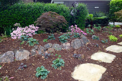 Imagen de jardín rústico de tamaño medio en primavera en patio delantero con exposición reducida al sol y adoquines de piedra natural