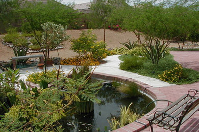 Inspiration for a mid-sized southwestern partial sun backyard brick water fountain landscape in Phoenix.