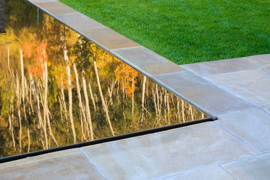 Foto de jardín minimalista grande en otoño en azotea con jardín francés, exposición parcial al sol, adoquines de piedra natural y fuente