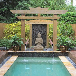 Photo of a mid-sized asian backyard water fountain landscape in Miami with decking.
