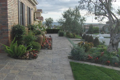 Großer Klassischer Vorgarten mit Auffahrt, direkter Sonneneinstrahlung und Natursteinplatten in Orange County