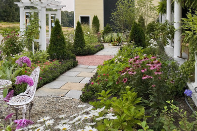 Cette photo montre un jardin chic de taille moyenne avec une exposition ensoleillée et des pavés en pierre naturelle.