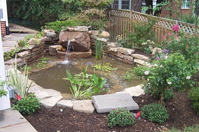 На фото: маленький тенистый садовый фонтан на заднем дворе в классическом стиле с покрытием из каменной брусчатки для на участке и в саду