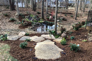 Photo of a traditional backyard stone water fountain landscape in Charlotte.