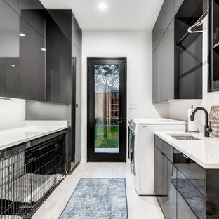Idee per una grande sala lavanderia minimal con ante lisce, ante nere, pareti bianche, pavimento in gres porcellanato, lavatrice e asciugatrice affiancate, pavimento nero e top bianco