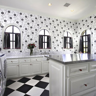 Idee per un'ampia sala lavanderia tradizionale con ante bianche, lavello sottopiano, ante con bugna sagomata, top in acciaio inossidabile, pareti bianche, pavimento con piastrelle in ceramica, lavatrice e asciugatrice affiancate, pavimento multicolore e top grigio