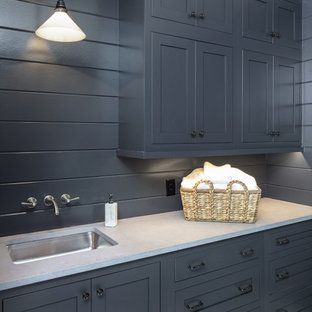 Ispirazione per una lavanderia multiuso classica di medie dimensioni con ante blu, top in cemento, pareti blu, pavimento con piastrelle in ceramica, lavatrice e asciugatrice affiancate, pavimento bianco e top beige