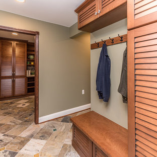 Ispirazione per una grande lavanderia multiuso stile americano con lavello stile country, ante a persiana, ante con finitura invecchiata, top in quarzo composito, pareti verdi, pavimento in ardesia, lavatrice e asciugatrice a colonna, pavimento multicolore e top grigio