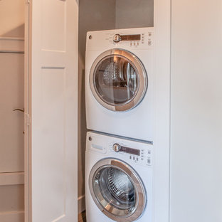 Laundry closet - small transitional linoleum floor laundry closet idea in Portland with white walls and a stacked washer/dryer