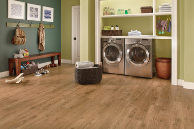 Large elegant medium tone wood floor and brown floor utility room photo in Kansas City with green walls and a side-by-side washer/dryer