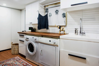 Inspiration for a small modern utility room remodel in Toronto with flat-panel cabinets