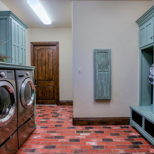 Idéer för ett stort rustikt blå parallellt grovkök, med tegelgolv, blå skåp, skåp i shakerstil, träbänkskiva, beige väggar, en tvättmaskin och torktumlare bredvid varandra och rött golv