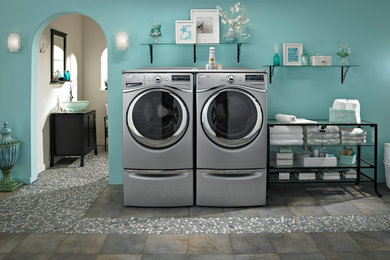 Foto de cuarto de lavado costero con paredes azules y lavadora y secadora juntas