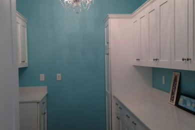 デンバーにある中くらいなシャビーシック調のおしゃれな洗濯室 (ll型、シェーカースタイル扉のキャビネット、白いキャビネット、珪岩カウンター、青い壁、濃色無垢フローリング、茶色い床) の写真