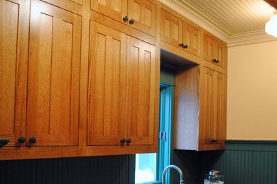 Example of a large cottage galley ceramic tile dedicated laundry room design in Grand Rapids with a drop-in sink, shaker cabinets, medium tone wood cabinets, quartz countertops, a side-by-side washer/dryer and beige walls