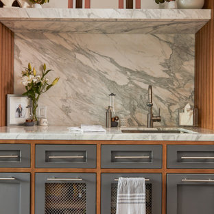 Idee per una grande lavanderia multiuso minimalista con lavello da incasso, ante in stile shaker, ante grigie, top in quarzo composito, paraspruzzi in quarzo composito, pareti bianche, pavimento in cemento, lavatrice e asciugatrice a colonna e pavimento grigio