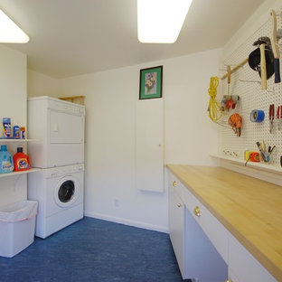 Ispirazione per una sala lavanderia tradizionale di medie dimensioni con ante lisce, ante bianche, top in legno, pareti bianche, pavimento in linoleum, lavatrice e asciugatrice a colonna e pavimento blu