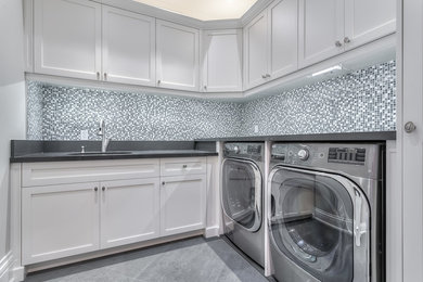 Example of a mid-sized transitional l-shaped porcelain tile dedicated laundry room design in Toronto with an undermount sink, shaker cabinets, white cabinets, beige walls and a side-by-side washer/dryer