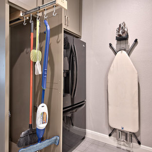 Idées déco pour une buanderie parallèle classique de taille moyenne et multi-usage avec un sol en carrelage de céramique, un placard à porte shaker, des portes de placard marrons, un plan de travail en quartz modifié, des machines superposées, un mur gris et un sol gris.