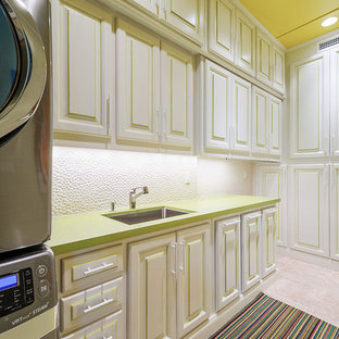 Foto di una sala lavanderia tropicale con lavello sottopiano, ante con bugna sagomata, ante bianche, pavimento beige e top verde