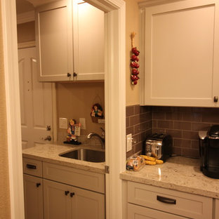 Immagine di una piccola sala lavanderia country con lavello sottopiano, ante in stile shaker, ante bianche, top in quarzo composito, pareti beige, pavimento in laminato e pavimento marrone