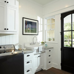 Dedicated laundry room - mid-sized traditional single-wall dark wood floor and brown floor dedicated laundry room idea in Austin with a farmhouse sink, shaker cabinets, white cabinets, granite countertops, white walls and a side-by-side washer/dryer