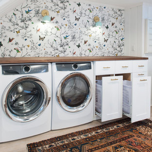 Idéer för ett mellanstort klassiskt grovkök, med luckor med infälld panel, vita skåp, träbänkskiva, vita väggar, ljust trägolv, en tvättmaskin och torktumlare bredvid varandra och beiget golv