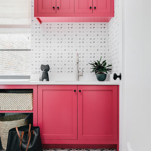 Immagine di una lavanderia tradizionale con lavello sottopiano, ante in stile shaker, ante rosse, pareti bianche, pavimento multicolore e top bianco