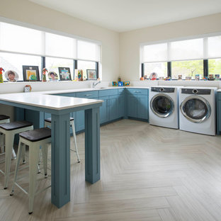 Idee per una lavanderia multiuso tradizionale con lavello sottopiano, ante in stile shaker, ante blu, pareti bianche, pavimento in bambù, lavatrice e asciugatrice affiancate, pavimento marrone e top bianco