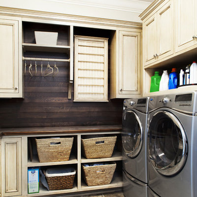 Example of a classic porcelain tile laundry room design in Jacksonville with beige cabinets, a side-by-side washer/dryer, recessed-panel cabinets, brown countertops and wood countertops
