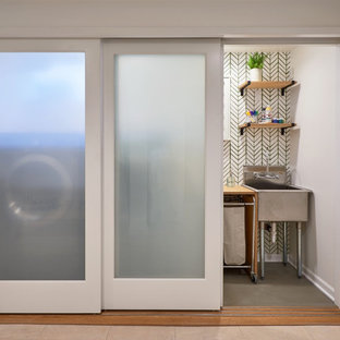 Mid-sized transitional single-wall concrete floor and green floor laundry closet photo in Seattle with an utility sink, wood countertops, green walls and a side-by-side washer/dryer
