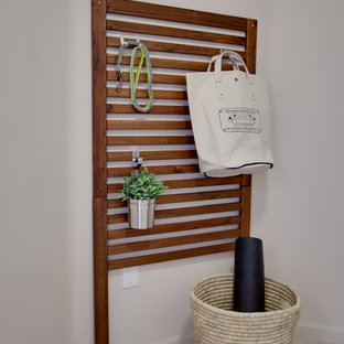 Exempel på en liten modern linjär tvättstuga enbart för tvätt, med beige väggar, klinkergolv i porslin och en tvättpelare