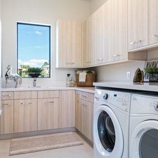 Ispirazione per una sala lavanderia contemporanea con lavello sottopiano, ante lisce, ante marroni, pareti bianche, lavatrice e asciugatrice affiancate, pavimento beige e top grigio