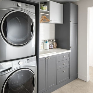 Esempio di una sala lavanderia design di medie dimensioni con lavello da incasso, ante in stile shaker, ante grigie, top in quarzo composito, pareti bianche, moquette, lavatrice e asciugatrice a colonna, pavimento beige e top bianco