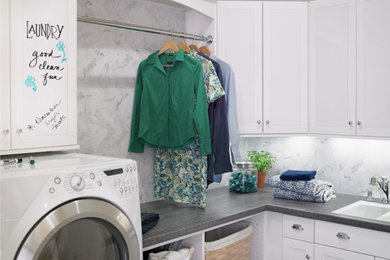 Ejemplo de cuarto de lavado lineal clásico renovado de tamaño medio con armarios estilo shaker, puertas de armario blancas, encimera de madera y lavadora y secadora juntas