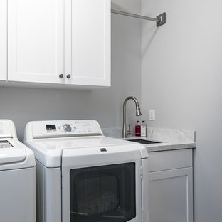 Ispirazione per una sala lavanderia tradizionale di medie dimensioni con lavello sottopiano, ante in stile shaker, ante bianche, top in marmo, pareti grigie, pavimento in gres porcellanato, lavatrice e asciugatrice affiancate e pavimento multicolore