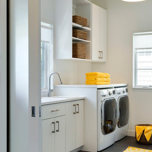 Réalisation d'une buanderie parallèle vintage multi-usage avec un évier posé, un placard à porte plane, des portes de placard blanches, un plan de travail en surface solide, un mur blanc, un sol en carrelage de porcelaine et des machines côte à côte.