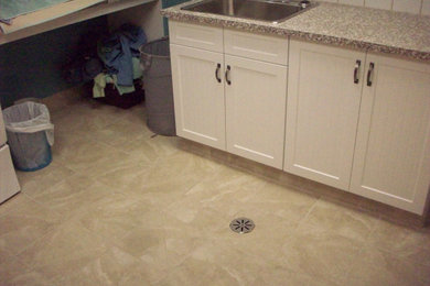 Example of a mid-sized trendy ceramic tile and beige floor dedicated laundry room design in Calgary with a drop-in sink, recessed-panel cabinets, white cabinets, laminate countertops, white backsplash, ceramic backsplash, blue walls, a side-by-side washer/dryer and beige countertops